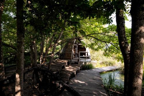a wooden path through a forest with trees at La Saline Royale in Arc-et-Senans