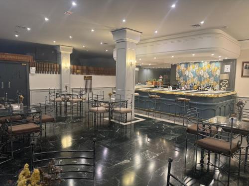 a bar in a restaurant with chairs and a counter at Hotel RL Anibal in Linares