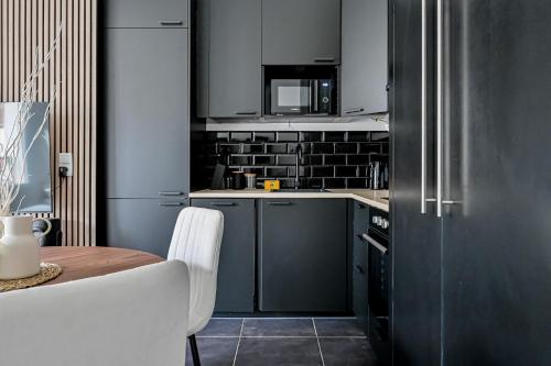a small kitchen with a table and a refrigerator at Le Nid - Proche Paris & Disney - Parking - WIFI in Villiers-sur-Marne
