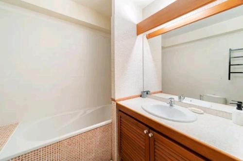 a bathroom with a sink and a bath tub at L'Emeraude - Studio proche du CHU in Saint-Denis