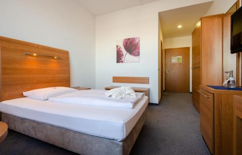 a hotel room with a large bed and a television at Hotel Fortuna Reutlingen-Tübingen in Reutlingen