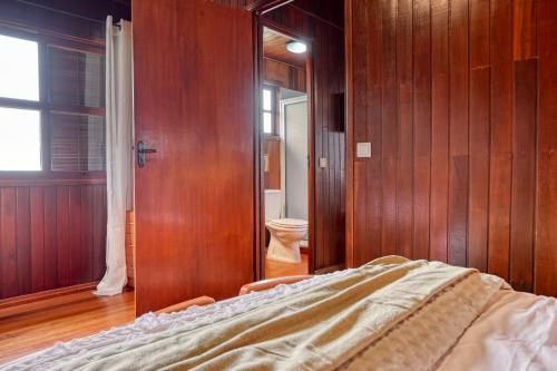 1 dormitorio con 1 cama y aseo en una habitación en Chalet do Relogio d'Agua, a Home in Madeira, en Ponta do Sol