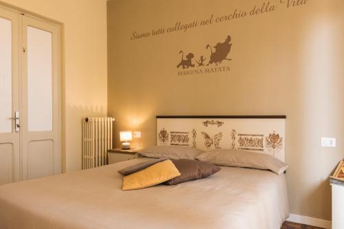 um quarto com uma cama branca e uma placa na parede em La Favola em Soriso