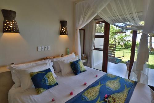 a bedroom with a bed with blue and white pillows at Casa Babi in Vilanculos