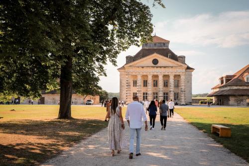 a group of people walking in front of a building at La Saline Royale in Arc-et-Senans