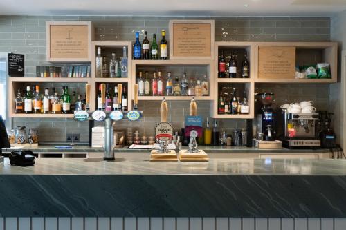 a bar with a lot of bottles of alcohol at Westmorland Hotel Tebay in Tebay