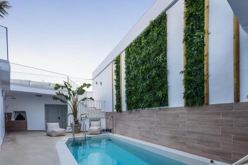 a swimming pool in a house with a green wall at Sun Moon Villas, True Nature Purity, By ThinkVilla in Atsipádhes
