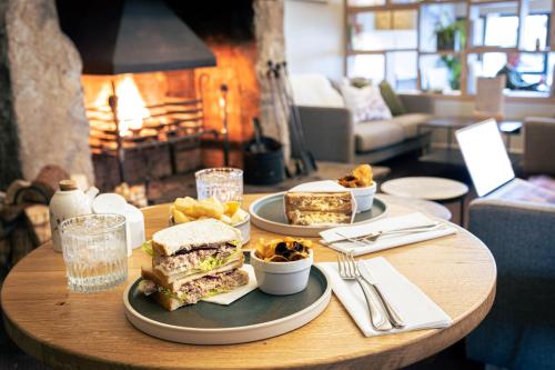 a table with a sandwich and some food on it at Westmorland Hotel Tebay in Tebay
