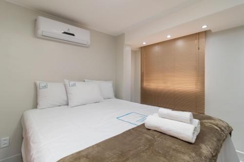 a bedroom with a white bed and a window at Residencial Oliveiras - Apartamento 3 in Brasilia