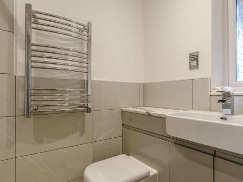 a white bathroom with a toilet and a sink at 1 Bed in Sennen 85566 in St Just