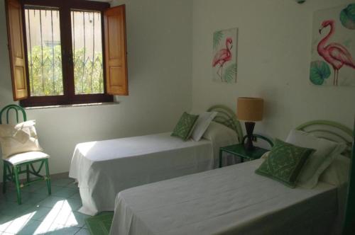 Zimmer mit 2 Betten und einem Vogel an der Wand in der Unterkunft Villa Maria in Cala Liberotto