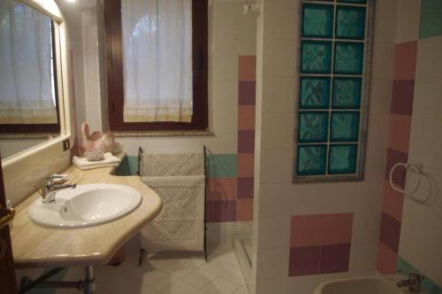 ein Badezimmer mit einem Waschbecken, einem Spiegel und einer Badewanne in der Unterkunft Villa Maria in Cala Liberotto