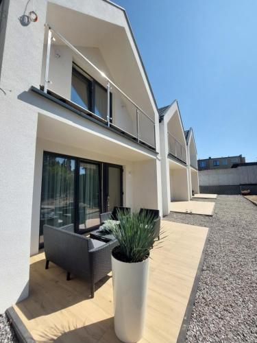 une maison avec une terrasse dotée d'une plante en pot dans l'établissement Domki Balticana, à Władysławowo