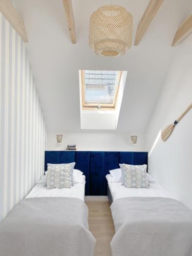 two beds in a room with a window at Domki Balticana in Władysławowo