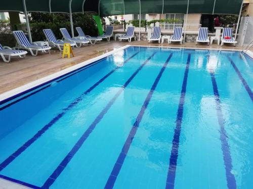 a swimming pool with blue water and chairs at Akdeniz Yaşam Otel in Silifke