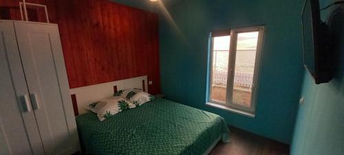 Un dormitorio con una cama verde y una ventana en Casuta camping BenBeach 