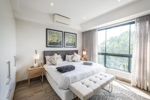 a bedroom with a large bed and a large window at Entire luxury 2 bedroom en-suite apartment at Regency Hotel in Pretoria