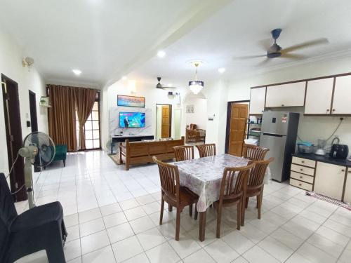 a kitchen and living room with a table and chairs at Rinting Corner Islamic Homestay, Pasir Gudang in Masai