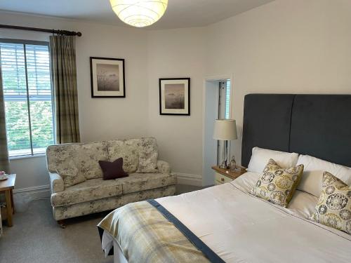 a bedroom with a bed and a couch and a chair at Elan Valley Hotel in Rhayader