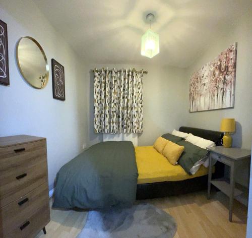 Large Cosy 2 bedroom Apartment in Stevenage SG1 Sleeps 5 في ستيفنيج: غرفة نوم بسرير ومكتب ومرآة