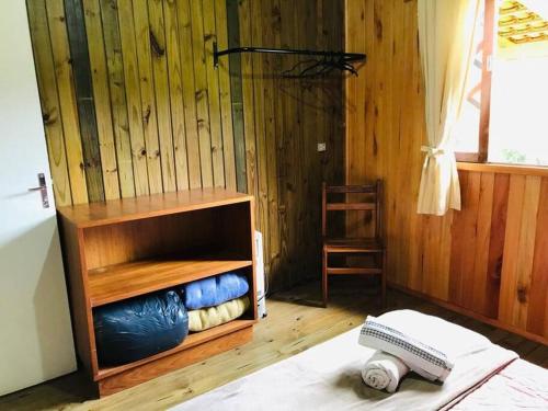 a room with a wooden wall with a wooden shelf at Casa Serrana in Barracão