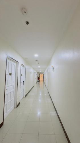 an empty hallway with white walls and white tile floors at La Anclar Hotel in Davao City