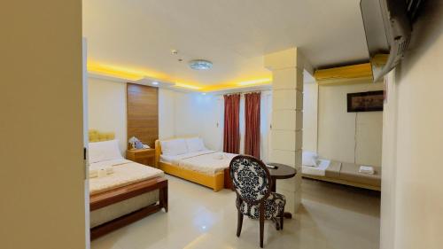 una habitación de hotel con 2 camas y una silla en La Anclar Hotel en Davao