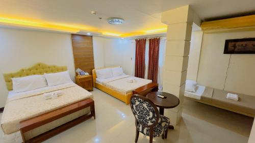Cette chambre comprend 2 lits et une table. dans l'établissement La Anclar Hotel, à Davao