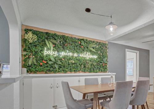 a dining room with a green wall with a table and chairs at Sheridan Wildflower Downtown Family Fun w Firepit in Colorado Springs