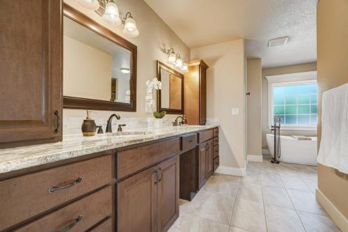 a bathroom with a sink and a mirror and a tub at Stargazer Paradise - Top Spot Hot Tub Gym Man Cave in Monument