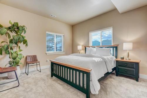 a bedroom with a bed and a chair and two windows at Stargazer Paradise - Top Spot Hot Tub Gym Man Cave in Monument