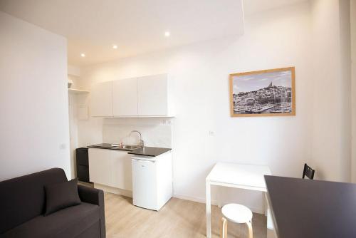 eine Küche und ein Wohnzimmer mit einem Sofa und einem Tisch in der Unterkunft Studio Saint Ferreol hyper centre 3-1 in Marseille