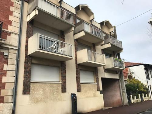 un chien assis sur un balcon d'un bâtiment dans l'établissement Appartement T2 Arcachon centre, commerces et plage à pied, à Arcachon