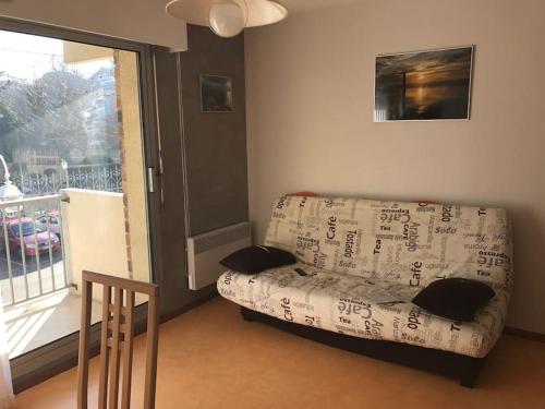 un salon avec un canapé et une fenêtre dans l'établissement Appartement T2 Arcachon centre, commerces et plage à pied, à Arcachon