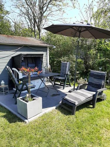 a patio with a table and chairs and an umbrella at Zum-Piraten in Damp