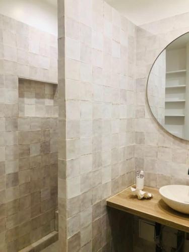 une salle de bain avec un lavabo et un miroir dans l'établissement La Belle Epoque, à Villers-sur-Mer