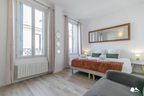 a bedroom with a bed and a mirror and a couch at MBA - Splendide Appart - Bobillot - Proche Vincennes in Montreuil
