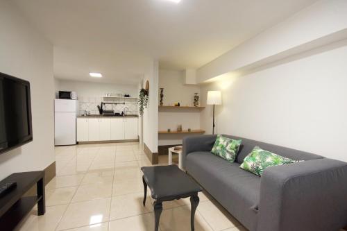 a living room with a couch and a kitchen at Two bedrooms apartment close to airport in Carrizal