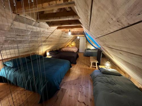 um quarto no sótão com 2 camas e um sofá em Buron Cœur d’Aubrac em Marchastel