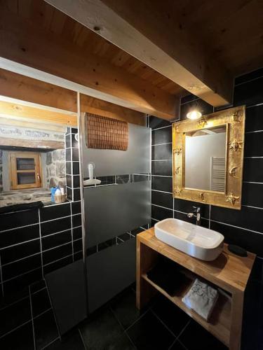 une salle de bain avec un lavabo et un miroir dans l'établissement Buron Cœur d’Aubrac, à Marchastel