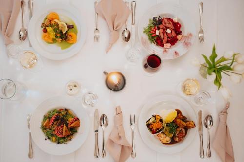 una mesa blanca con platos de comida. en Penzión Kráľov Prameň, en Spišská Nová Ves