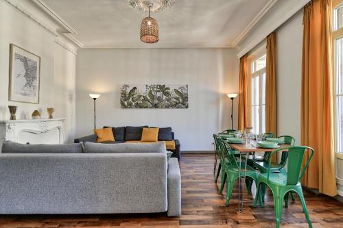 - un salon avec un canapé et une table avec des chaises vertes dans l'établissement NOCNOC - Le Balcon de Colbert, à Marseille