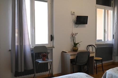 1 dormitorio con escritorio, mesa y 2 sillas en Bovisa House B&B private rooms, en Milán