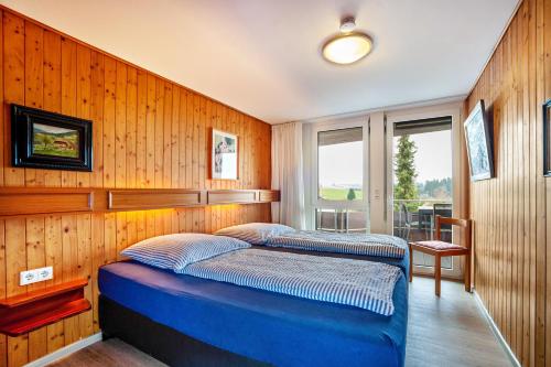 two beds in a room with wooden walls at Ferienhaus Rommel in Stiefenhofen