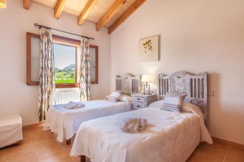 two beds in a room with a window at Villa Guillona in Alcudia