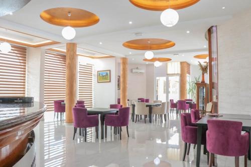 een eetkamer met paarse stoelen en tafels bij Imperial Hotel in Ulcinj