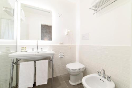 a white bathroom with a sink and a toilet at Amalfi Luxury House in Amalfi