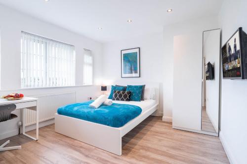 una camera bianca con letto e scrivania di 4 Bedroom House - Parking & Garden - Smart TVs - Netflix - Wifi - 22CG a Birmingham
