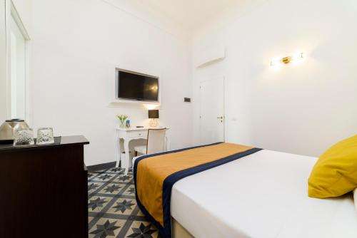 a bedroom with a bed and a desk and a television at Amalfi Luxury House in Amalfi