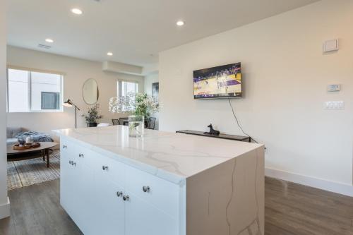 a kitchen with a large white island in a living room at Metro Horizon by AvantStay Rooftop Deck City View in Los Angeles